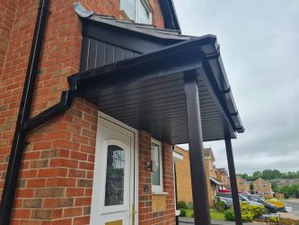 Black uPVC fascias, soffits and guttering fitted to a porch canopy and dormer