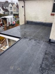 Extension flat roof installation with EPDM membrane dressed up the house wall