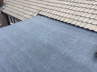 EPDM flat roof neatly detailed against a tiled pitched roof junction