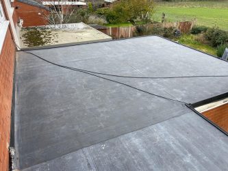 L-shaped rear extension EPDM flat roof with clean seam and corner detailing