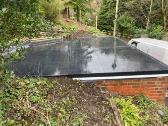 Newly completed garage EPDM rubber roof with watertight finish after heavy rain