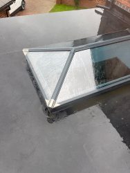 Roof lantern flashing detail on an EPDM rubber flat roof after rainfall