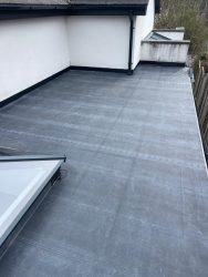 Wraparound EPDM flat rubber roof with roof lantern on a modern rendered property